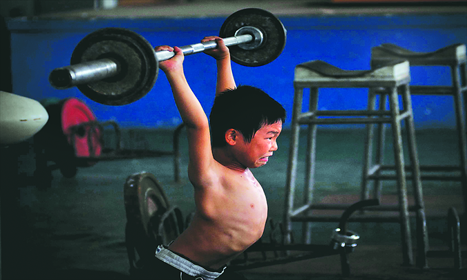 Main: A boy practises weightlifting in Xiamen Sports School, now the Xiamen Competitive Sports Management Center. Photo: CFP