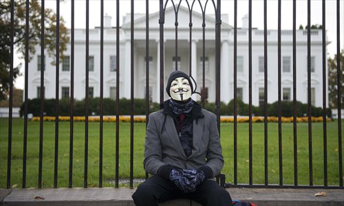 A demonstrator, and supporter of the group Anonymous, rests during a protest against corrupt governments and corporations in front of the White House in Washington, DC. Tuesday saw a Million Mask March of similar rallies around the world on Guy Fawkes Day.  Photo: AFP