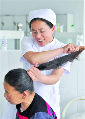 Nurse Li Dongmei combs the hair of a new patient. Photo: IC