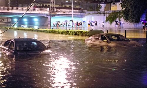 Two cars are inundated in the water near Lianhua bridge in southern Beijing early on Sunday, after the heaviest rainstorm in 61 years hit the capital on Saturday. Photo: Li Hao/GT