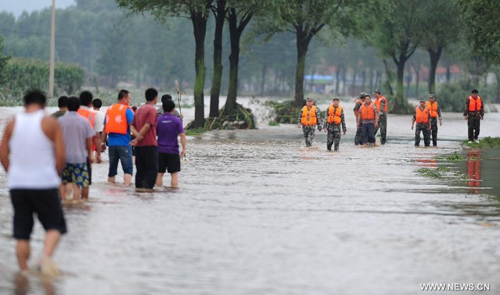 Rescuers are seen in Daweizi village of Xiuyan, northeast China's Liaoning Province, Aug. 5, 2012. Nearly 1.46 million people in Liaoning were affected by heavy rains and floods caused by Typhoon Damrey, authorities said Sunday. Photo: Xinhua