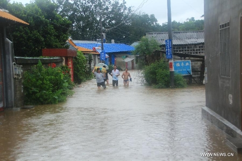 Local residents walk in the flooded street in Pingyuan Town of Yingjiang County, southwest China's Yunnan Province, July 8, 2013. Rainstorm-triggered floods have affected about 4,882 people in the county, causing damages to local agriculture and houses. The rescue operation is under way. (Xinhua)