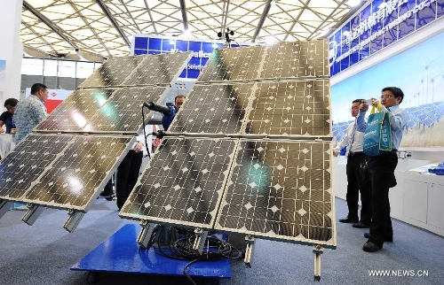 Visitors watch the photovoltaic products during the 2013 international photovoltaic exhibition in east China's Shanghai Municipality, May 14, 2013. The four-day exhibition, with the participation of more than 1,500 exhibitors, opened here Tuesday. (Xinhua/Lai Xinlin)