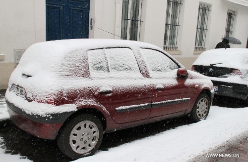&nbsp; Photo taken on March 12, 2013 shows snow-covered cars on the street of Paris, capital of France. According to Meteo France, the country's weather agency, two departments were put under red alert and 27 others including Paris and suburbs under orange alert on predicted heavy snowfall till Wedenesday morning. (Xinhua/Zheng Bin) 