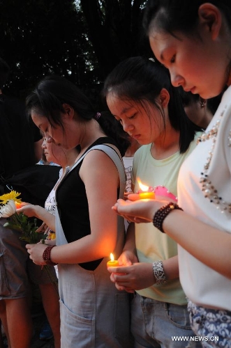 Students light candles to mourn the death of Wang Jialin and Ye Mengyuan, two young girls killed in a crash landing of an Asiana Airlines Boeing 777 at San Francisco airport, in Jiangshan City, east China's Zhejiang Province, July 8, 2013. Local residents gathered at Xujiang Park in Jiangshan to show their grief to the 17-year-old Wang and 16-year-old Ye, who were students from Jiangshan High School. (Xinhua/Huang Shuifu)