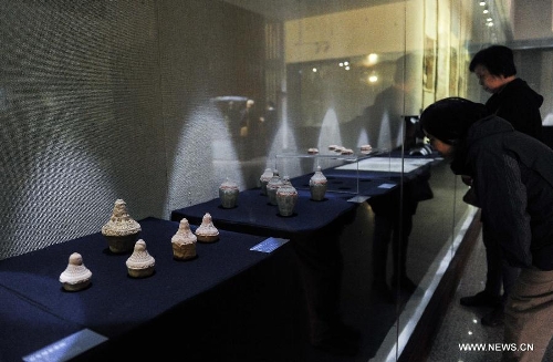 Visitors appreciate cultural relics of the Kingdom of Xia on display in an exhibition in Changchun, capital of northeast China's Jilin Province, May 15, 2013. An exhibition of the cultural relics of the Kingdom of Xia, a regime founded in west China in 1038, was held here on Wednesday, in which more than 100 cultural relics of the kingdom excavated since the founding of the People's Republic of China in 1949 were shown to the public. (Xinhua/Xu Chang) 
