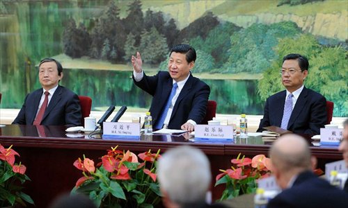 Xi Jinping (C back), general secretary of the Communist Party of China (CPC) Central Committee, communicates with foreign experts working in China during a meeting in Beijing, capital of China, December 5, 2012. It is Xi's first meeting with foreign guests since he was elected general secretary of the CPC Central Committee. Photo: Xinhua