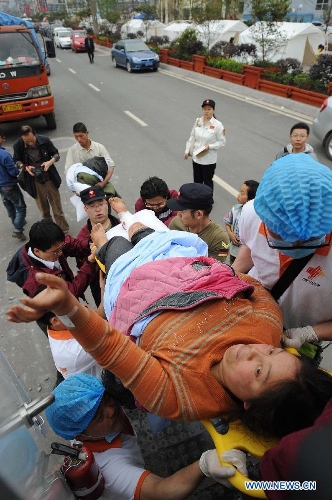 Health workers of Chongqing emergency medical service team carry an injured person transported from the quake-hit Baoxing County in southwest China's Sichuan Province, April 21, 2013. al authorities. (Xinhua/Li Jian) 