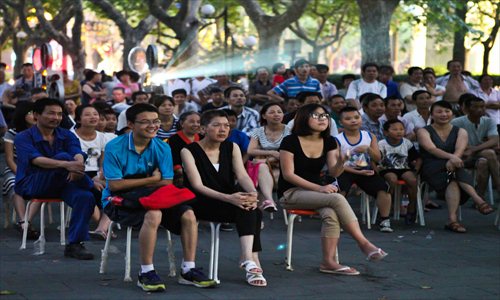 Residents enjoy an outdoor movie at Xiangyang Park in Xuhui district. Several parks in the city have begun to host free movies for residents this month. Photo: Xinhua