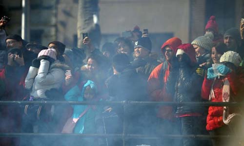 People stand and watch as firecrackers are set off to celebrate the Chinese Lunar New Year in Chinatown, in downtown Manhattan of New York City on Feb. 10, 2013. Photo: Xinhua