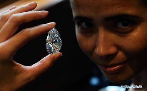 A worker shows the 101.73-carat diamond to the media at the Christie in Geneva, Switzerland, April 30, 2013. Christie will hold spring sale of Jewels auction in Geneva on May 15, 2013. Led by a truly sensational pear-shaped, D colour, flawless diamond of 101.73 carats, the sale will reach to an estimated combined total of 65 million dollars. This Type IIA Flawless gem was found at the Jwaneng mine in Botswana and took 21 months to polish. This gemstone is estimated to be sold at a price between 20 to 30 million dollars and the successful buyer will have the privilege of endowing the diamond a name. (Xinhua/Wang Siwei) 