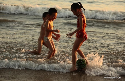 Children play along the seaside in Sanya, south China's Hainan Province, May 20, 2013. (Xinhua/Chen Wenwu) 