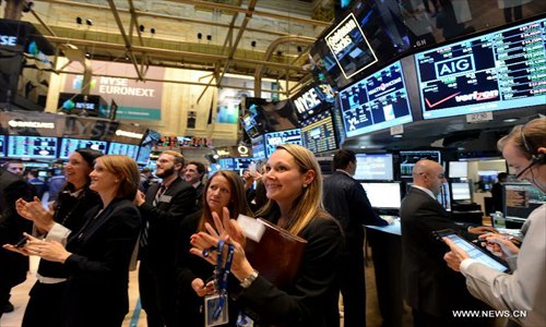 Traders applaud on the floor of the New York Stock Exchange, New York, the United States, on January 2, 2013.