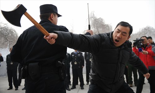 A police officer teaches combat skills to staff of Urumqi public security bureau, Xinjiang Uyghur Autonomous Region Wednesday. Staff will be trained in how to deal with attacks from weapons like knives and to improve safety awareness. Photo: CFP