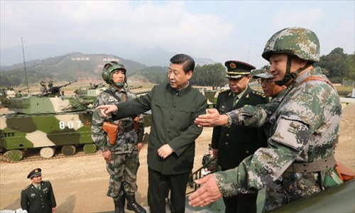 General Secretary of the Communist Party of China (CPC) Central Committee Xi Jinping (C), who is also the chairman of the CPC Central Military Commission, examines an armored vehicle at the Guangzhou military theater of operations of the People's Liberation Army (PLA), December 10, 2012. Xi made an inspection at the PLA's Guangzhou military theater of operations, a term usually used to emphasize the coordination and joint operations by forces in air, land and sea, from December 8 to 10. Photo: Xinhua