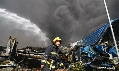 A firefighter is seen on the accident site in Guali Township of Xiaoshan District in Hangzhou, capital of east China's Zhejiang Province, January 1, 2013. A fire broke out in the Hangzhou Yusei Machinery Co.Ltd at the Lingang Industrial Park in Guali Township early Tuesday morning. Three firefighters were killed when putting out the fire. By now, firefighters are still trying to douse the blaze. Photo: Xinhua