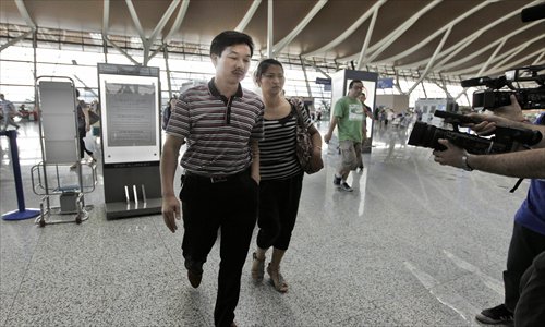 The parents of Wang Linjia, one of the Chinese girls killed in the Asiana accident at San Francisco airport, prepare to board the flight for Seoul Monday afternoon at the Shanghai Pudong International Airport. From Seoul, they will fly eastward to San Francisco. Photo: Yang Hui/GT