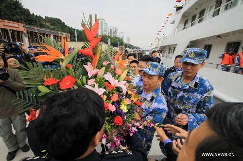 People send flowers to crew members on Chinese fishery patrol ship 44608 for their return at Yuzheng port in Shantou, south China's Guangdong Province, March 30, 2013. The patrol ship 44608 finished its 23-day patrol cruise around Huangyan Islands on Saturday and returned to Shantou. (Xinhua/Yao Jun) 