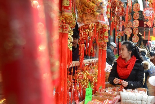 A local Chinese looks at the traditional decorations for the upcoming Chinese Lunar New Year in China Town, New York, the United States, Feb. 6, 2013. The Chinese Lunar New Year, or Spring Festival, starts on Feb. 10 this year. (Xinhua/Wang Lei)  