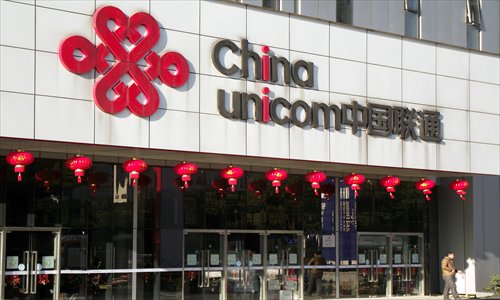 A man stands in front of a China Unicom branch in Shanghai. China United Network Communications Ltd announced Thursday in a filing with the Shanghai Stock Exchange that its controlling shareholder China United Network Communications Group Co Ltd increased its holding by 249 million shares over past 12 months. Photo: CFP