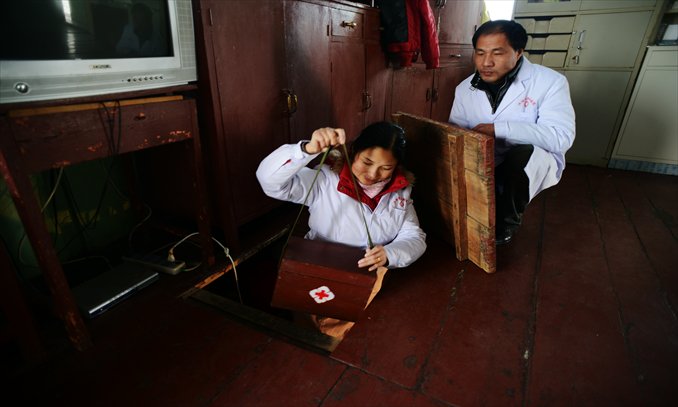 He watches his wife as she leaves to take care of patients. Photo: CFP