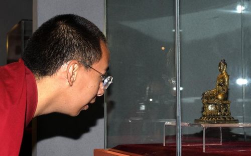 The 11th Panchen Lama Bainqen Erdini Qoigyijabu views a Buddha statue during an exhibition of Tibet cultural relics returned from overseas in Tibet Museum in Lhasa, capital of Southwest China's Tibet Autonomous Region, July 28, 2012. Photo: Xinhua