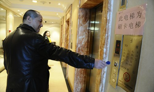 A man swipes his card to take an elevator at the building Wednesday. Photo: Li Hao/GT