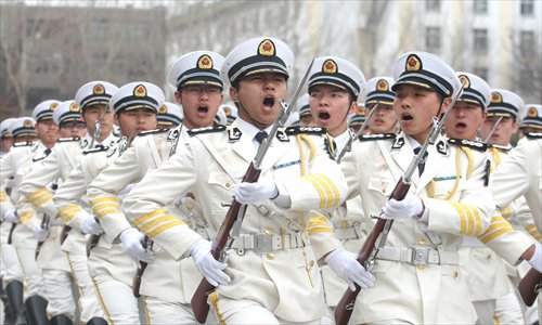 A total of 300 national defense students from Harbin Engineering University in Heilongjiang Province participate in a military parade on Tuesday while wearing full uniform and carrying rifles. The event was meant to mark the 64th anniversary of the People's Liberation Army Navy in China. Photo: CFP
