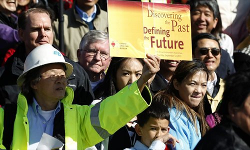 A man holds a sign up on Saturday as members of the Asian-American Community from around the US and from Guangdong Province in South China celebrate the 145th anniversary of the completion of the Transcontinental Railroad, at Promontory Point, Utah, the US on Saturday. A ceremony, including guest speakers, a remembrance for those who lost their lives while building the railroad, two re-enactment ceremonies and live music, was held to mark the anniversary.