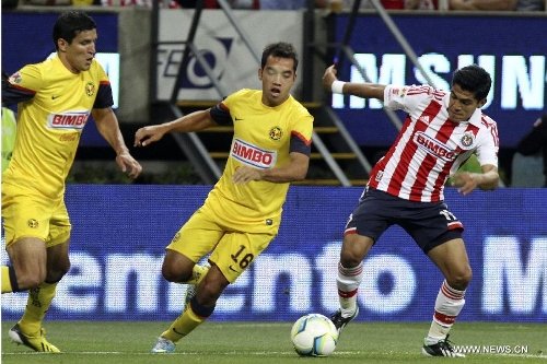 Chivas' Jesus Enrique Sanchez (R) vies for the ball with Francisco Rodriguez (L) and Adrian Aldrete of America during a Liga MX soccer match at the Omnilife Stadium in Zapopan, Mexico, on March 31, 2013. (Xinhua/StraffonImages) 
