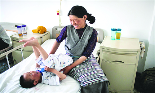 Sonam Tsering, 7, an active and happy boy, seems upbeat on his ward bed, with his mother beside him. Photo: Li Hao/GT