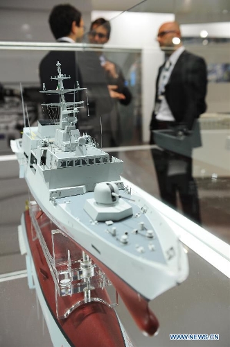 Guests talk with each other in front of an Italian company's warship model in Istanbul, Turkey, May 7, 2013. The 11th International Defence Industry Fair was opened on Tuesday, with 781 companies from 82 countries and regions attending the four-day fair. (Xinhua/Lu Zhe) 