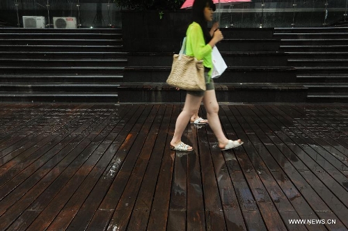 Pedestrians walk amid rain in Shenzhen, south China's Guangdong Province, May 26, 2013. Torrential rain hit most parts of Guangdong Province from Saturday to Sunday. (Xinhua/Mao Siqian)&nbsp; 