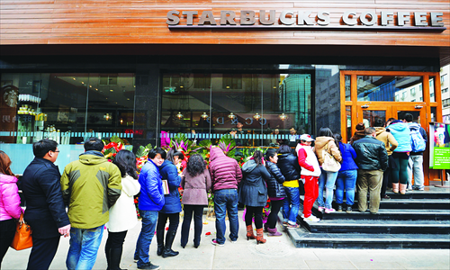 Customers wait in line to get into the first Starbucks Coffee to open in Taiyuan, provincial capital of Shanxi. The US coffee chain announced Sunday that it will open 1,500 new stores in the country by the end of 2015, adding 18,000 new employees to its payroll. Photo: CFP 