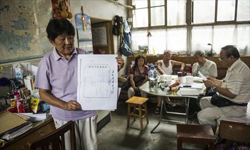 Qian Juping holds a copy of the title deed to the house her family owned before it was seized by Beijing housing authorities in 1958. Photo: Li Hao/GT
