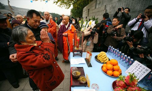 A Nanjing Massacre survivor (L, front) attends a religious service at the Memorial Hall of the Victims in Nanjing Massacre by Japanese Invaders in Nanjing, capital of east China's Jiangsu Province, December 13, 2012, to mark the 75th anniversary of the Nanjing Massacre. Nanjing was occupied on December 13, 1937, by Japanese troops who began a six-week massacre. Records show more than 300,000 Chinese unarmed soldiers and civilians were killed. Photo: Xinhua 