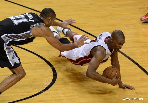 Chris Bosh (C) of Miami Heat saves the ball during Game 6 of the NBA Finals against San Antonio Spurs in Miami, the United States, June 18, 2013. Miami won 103-100. (Xinhua/Wang Lei) 