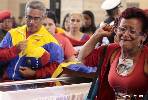 Image provided by the Presidency of Venezuela shows residents react as visiting the coffin keeping the remains of late Venezuelan President Hugo Chavez, at the Military Academy of Venezuela in the city of Caracas, capital of Venezuela, on March 10, 2013. Venezuela's National Electoral Council (CNE) announced on Saturday after a special meeting of its Board of Directors that the presidential elections will be held on April 14.(Xinhua/Presidency of Venezuela) 