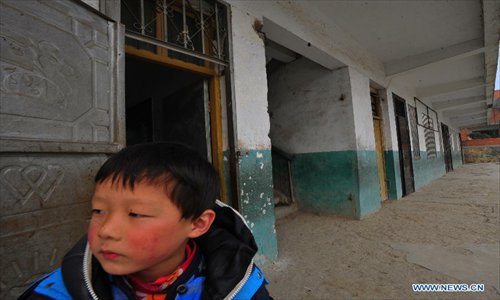 A student stands by the scene of a stampede accident at the Qinji Elementary School in Xueji County of Xiangyang, central China's Hubei Province, Feb. 27, 2013. Four students were killed in a stampede accident here on Wednesday morning. Relevant departments of Xiangyang have rushed to the scene to carry out rescue efforts, and the injured have been sent to hospital for treatment. The cause of the accident is under investigation. Photo: Xinhua