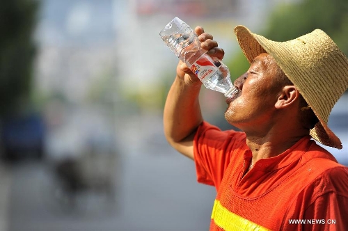 A sanitationman drinks water in Xiangyang City, central China's Hubei Province, June 18, 2013. The highest temperature in many parts of China reached 37 degrees centigrade Wednesday. (Xinhua/Yang Tao)
