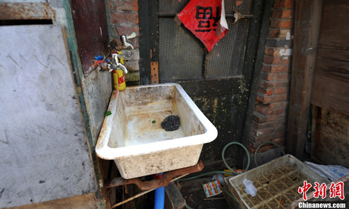 A rusty sink outside a small brick shack. Photo: Jin Shuo/chinanews.com 
