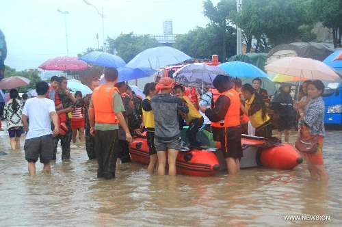Officers transfer children with a kayak at a kindergarten in Yingjiang County, southwest China's Yunnan Province, July 8, 2013. Rainstorm-triggered floods have affected about 4,882 people in the county, causing damages to local agriculture and houses. The rescue operation is under way. (Xinhua)