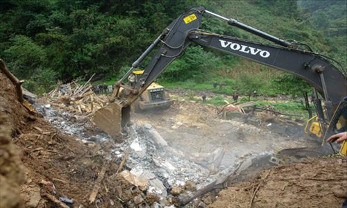 Rescuers search at the landslide site in the village of Zhenhe, located in Yiliang County of Zhaotong City in southwest China's Yunnan Province, October. 4, 2012. Nineteen people, including 18 students, were buried in a landslide here on Thursday. Eighteen people have been confirmed dead and one people remain missing. Photo: Xinhua