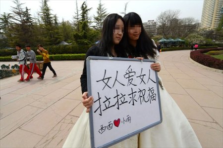 Lesbian lovers Xixi and Xiaoyu held a wedding ceremony in a park in Lanzhou, northwest China's Gansu province on April 15, 2013. Wearing wedding dress and holding a sign reading 