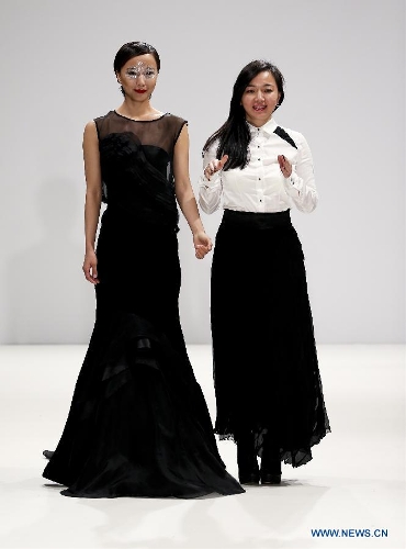 Chinese actress Wang Luodan (L) and Chinese designer Jenny Ji greet to audience after Jenny Ji's fashion show during London Fashion Week in London, Britain, on Feb. 18, 2013. (Xinhua/Tang Shi)
