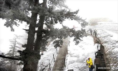 Visitors climb steep stairs in Huashan Mountain, a famous tourism destination in north China's Shaanxi Province, December 28, 2012