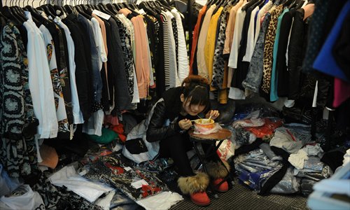 A woman eats her lunch in a shop in a wholesale clothing market in Shanghai. China's manufacturing growth hit a four-month low in February but remained positive, British banking giant HSBC said Monday, noting that the world's second-biggest economy was still recovering slowly (see story on page 22). Photo: AFP