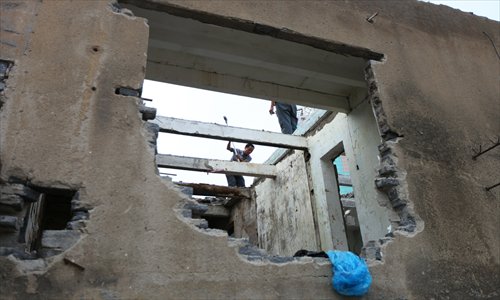 Workers knock down the solid concrete walls of a building on Chang'an Road West. Photo: Cai Xianmin/GT 