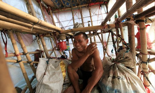 Liu Lingchao carries his portable house at the Liucheng county section of the G209 national highway in Liuzhou, Guangxi Zhuang Autonomous Region, on Wednesday. Liu, 38, from Longcheng village of Rongan county, Guangxi, left Shenzhen, Guangdong Province, five years ago to walk to his hometown, and has walked roughly 1,000 kilometers. He refused other people's help and earns money by collecting plastic bottles and other waste materials. Photo: CFP