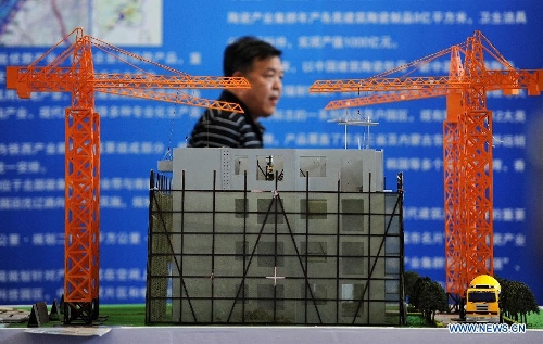 A man walks past an architecture model during the 2013 China (Shenyang) International Architecture Exposition in Shenyang, capital of northeast China's Liaoning Province, May 20, 2013. The three-day expo kicked off on Monday, with 615 enterprises from home and abroad participated. (Xinhua/Yao Jianfeng)